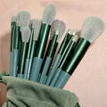 13 PCS green makeup brushes set including eye shadow and foundation brushes displayed on a soft background.